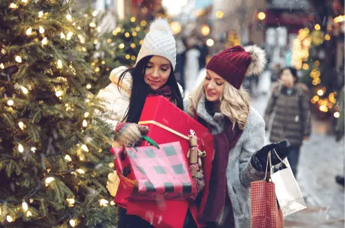 Zwei Frauen mit Weihnachtsgeschenken in der Stadt